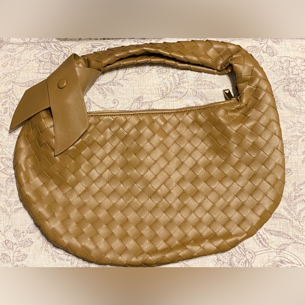 Braided vegan leather handbag zip top  with removable bow.
